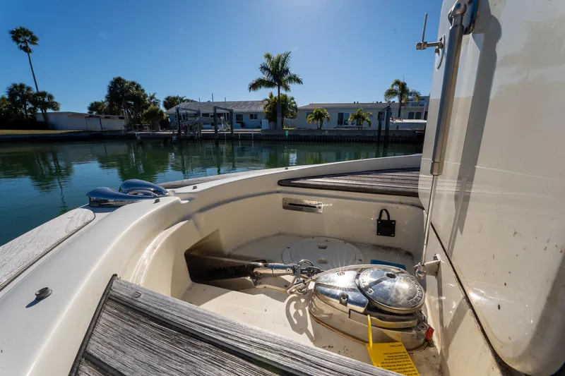 Slide: The Image of 2018 Chris-Craft Calypso 26 boat interior with anchor, docked near palm trees. - 38