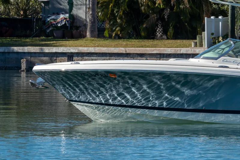 Slide: The Image of 2018 Chris-Craft Calypso 26 boat on calm water, reflecting sunlight. - 8
