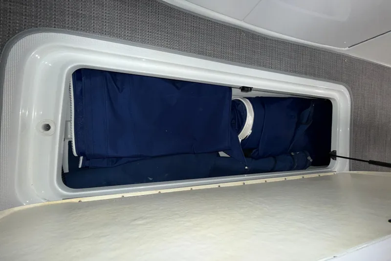 Slide: The Image of Storage compartment in a 2007 Formula 280 Bowrider boat, containing blue fabric items. - 24