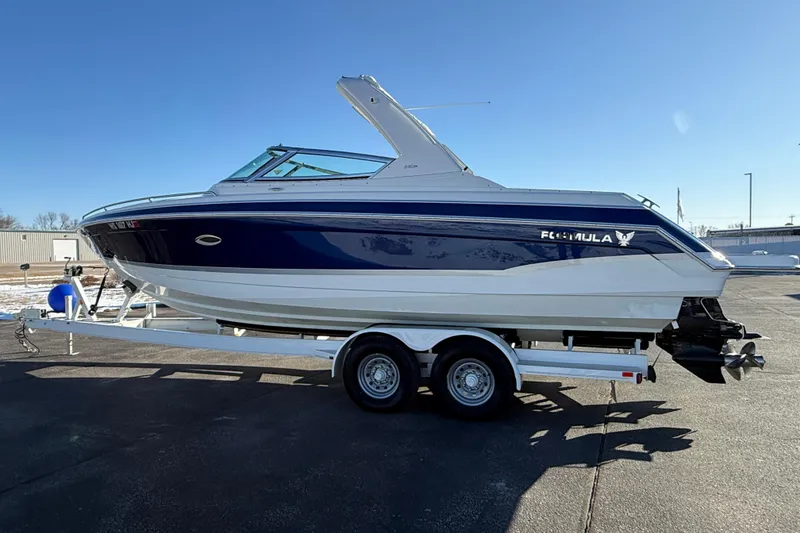 Slide: The Image of 2007 Formula 280 Bowrider boat on trailer, blue and white design, parked outdoors. - 4