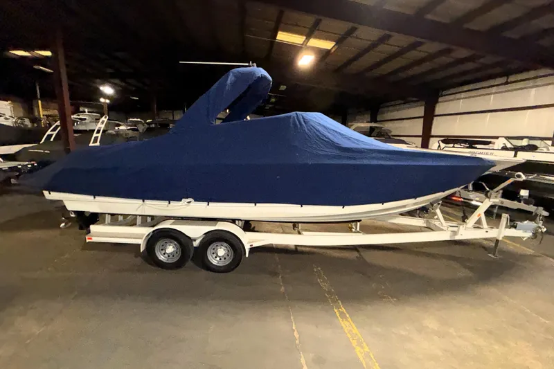 Slide: The Image of 2007 Formula 280 Bowrider boat covered in blue tarp on trailer in storage facility. - 46