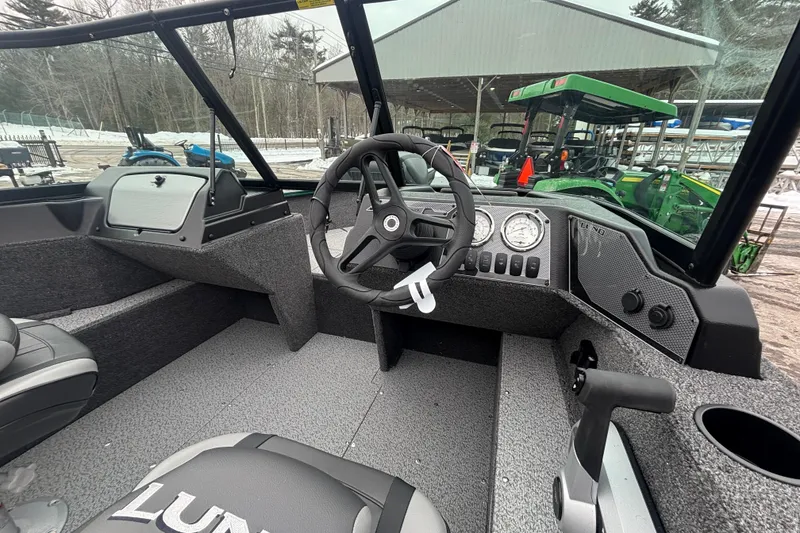 Slide: The Image of 2026 Lund 1650 Rebel XL Sport boat interior with steering wheel and dashboard controls. - 12