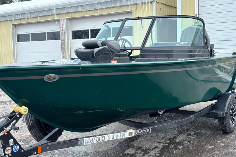 Slide: The Image of 2026 Lund 1650 Rebel XL Sport boat on trailer, parked outside a garage. - 5