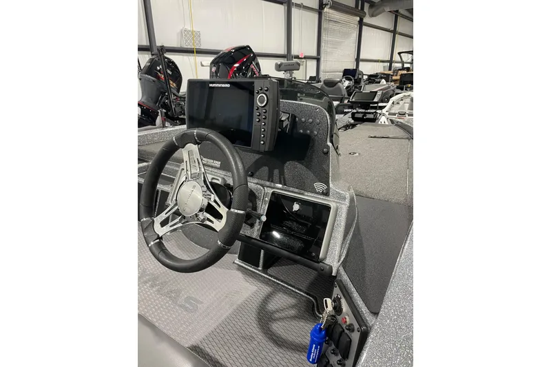 Slide: The Image of 2023 Caymas CX 18 S boat dashboard with steering wheel and electronic display. - 9