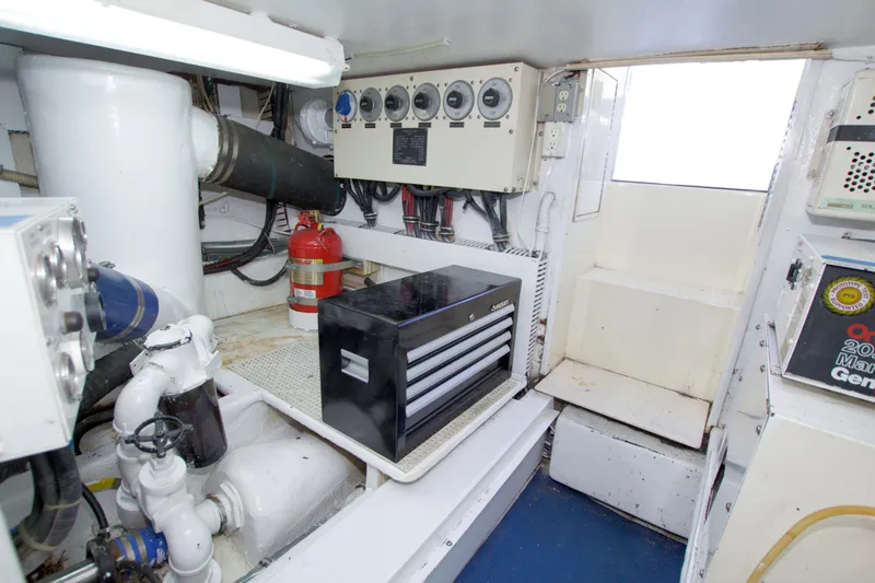 Slide: The Image of Engine room of 1990 Viking 53 Convertible yacht with control panel and fire extinguisher. - 101