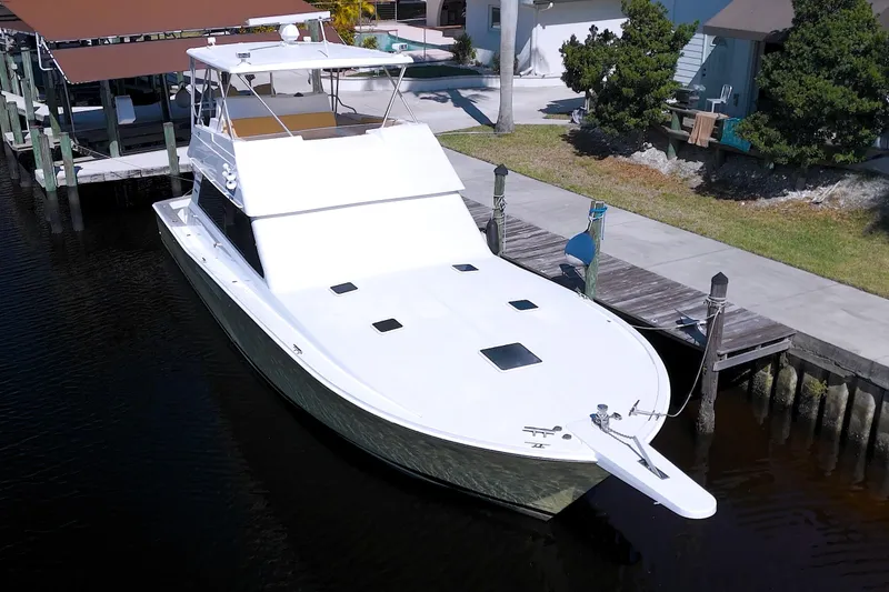 Slide: The Image of 1990 Viking 53 Convertible yacht docked at a marina, showcasing sleek design and spacious deck. - 11