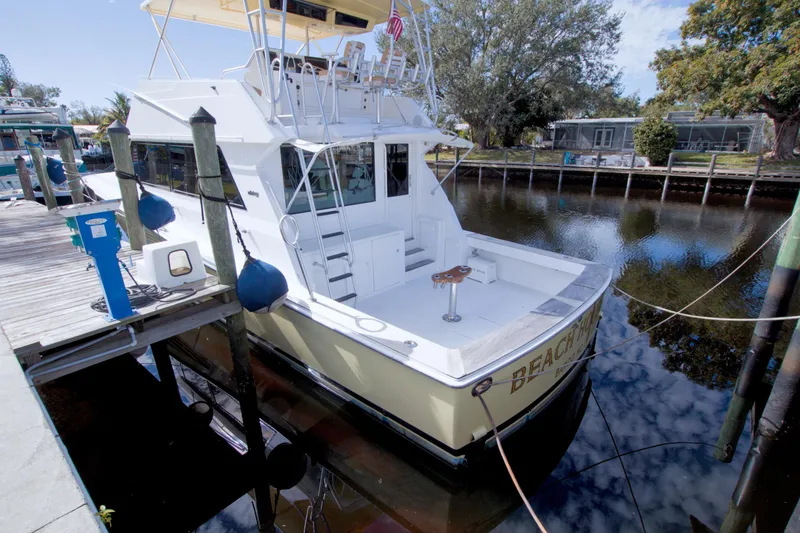 Slide: The Image of 1990 Viking 53 Convertible yacht docked in a serene marina setting. - 17