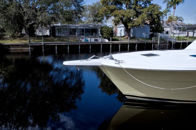 Slide: The Image of Bow of a 1990 Viking 53 Convertible yacht docked by a waterfront home. - 2