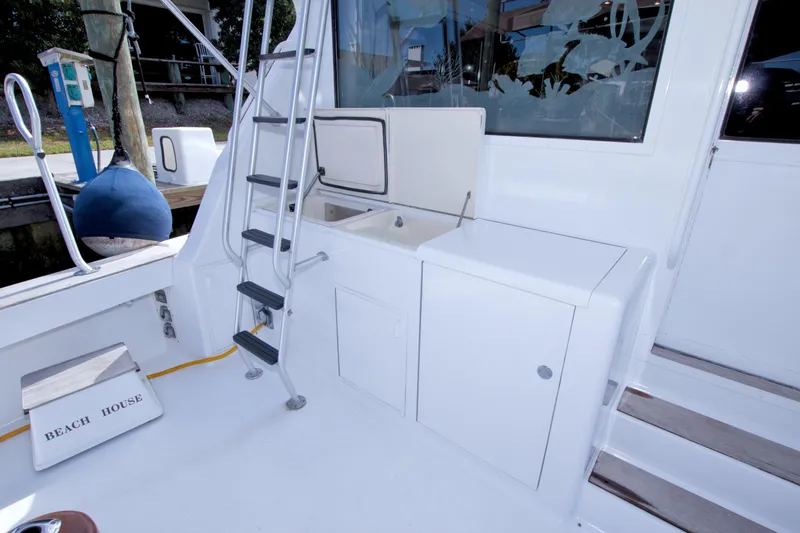 Slide: The Image of 1990 Viking 53 Convertible yacht deck with ladder, sink, and storage. - 21