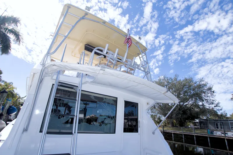 Slide: The Image of 1990 Viking 53 Convertible yacht with flybridge, docked under a bright blue sky. - 23