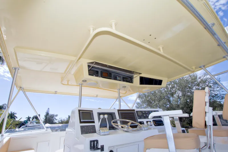 Slide: The Image of 1990 Viking 53 Convertible yacht helm with navigation equipment and seating under canopy. - 24