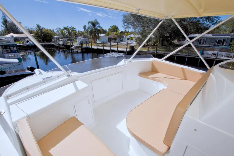 Slide: The Image of 1990 Viking 53 Convertible yacht with spacious outdoor seating area, docked by a serene waterfront. - 32