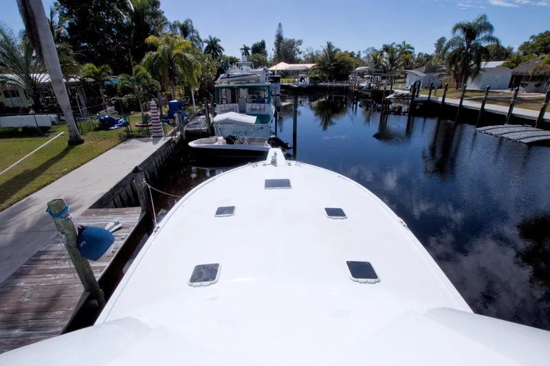 Slide: The Image of Bow view of a 1990 Viking 53 Convertible yacht docked in a serene marina. - 33