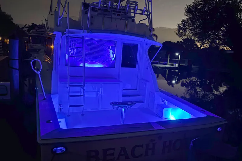 Slide: The Image of 1990 Viking 53 Convertible yacht with blue LED lights at night. - 38