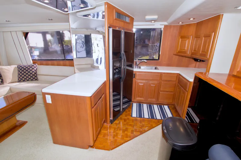 Slide: The Image of Luxurious kitchen interior of 1990 Viking 53 Convertible yacht with wood cabinetry and modern appliances. - 48