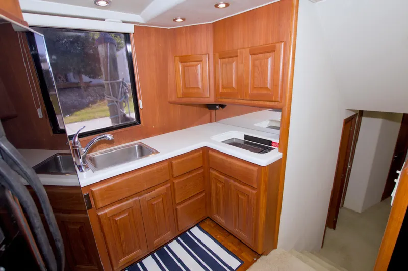 Slide: The Image of 1990 Viking 53 Convertible yacht kitchen with wooden cabinets and modern fixtures. - 50