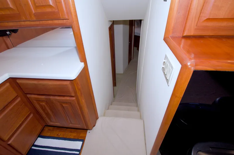 Slide: The Image of Interior of 1990 Viking 53 Convertible yacht with wooden cabinetry and narrow staircase. - 51