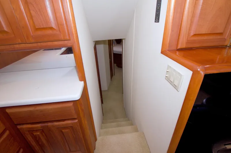 Slide: The Image of Interior view of 1990 Viking 53 Convertible yacht, featuring wooden cabinetry and narrow staircase. - 52