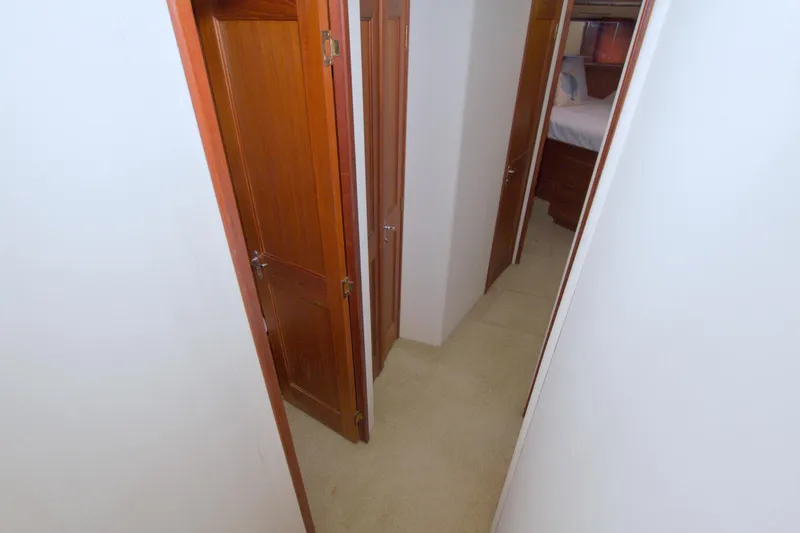Slide: The Image of Narrow hallway with wooden doors inside a 1990 Viking 53 Convertible yacht. - 53