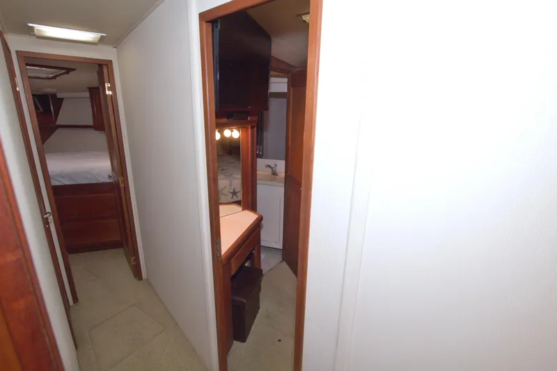 Slide: The Image of Interior hallway of 1990 Viking 53 Convertible yacht, featuring wood accents and cozy cabin spaces. - 54