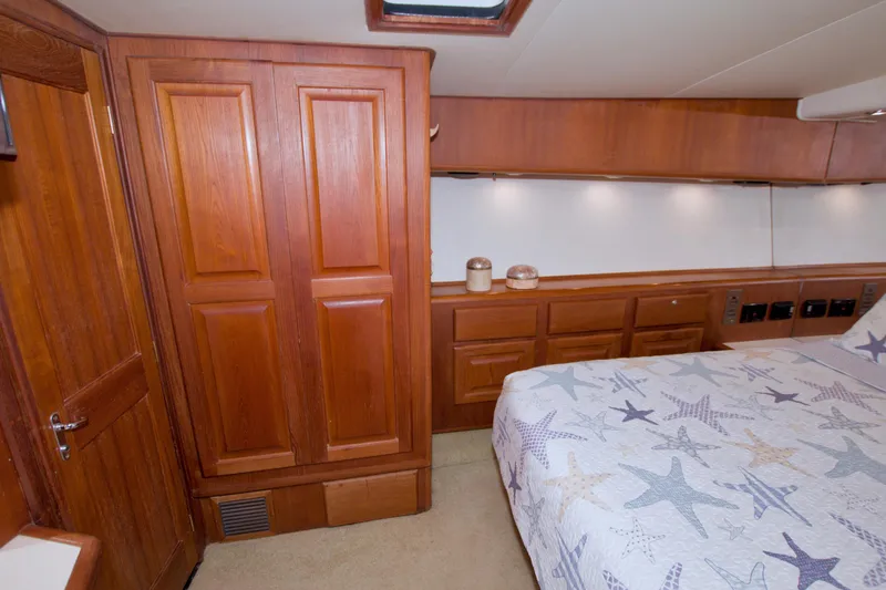 Slide: The Image of Luxurious cabin interior of 1990 Viking 53 Convertible yacht with wooden cabinetry and starfish bedding. - 56