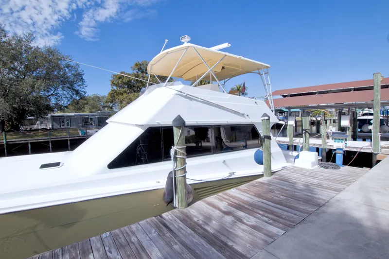 Slide: The Image of 1990 Viking 53 Convertible yacht docked at marina under clear blue sky. - 6