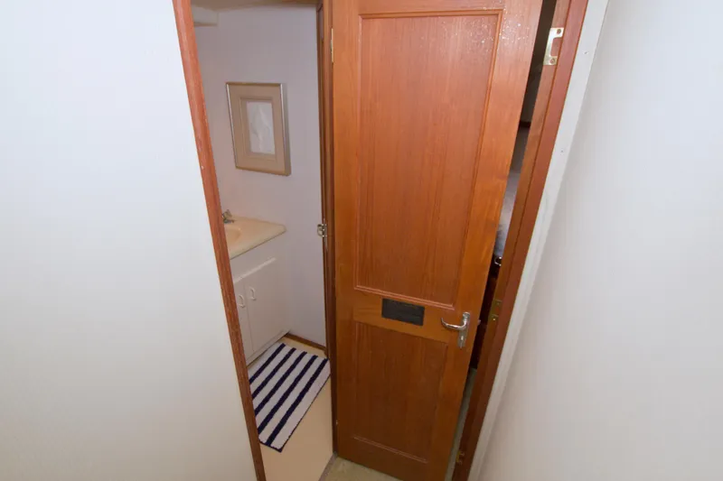 Slide: The Image of Interior of 1990 Viking 53 Convertible yacht bathroom with wooden door and striped rug. - 61