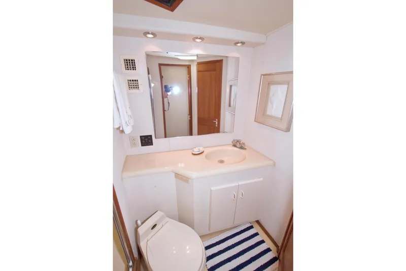 Slide: The Image of Bathroom interior of 1990 Viking 53 Convertible yacht, featuring sink, mirror, and striped rug. - 63