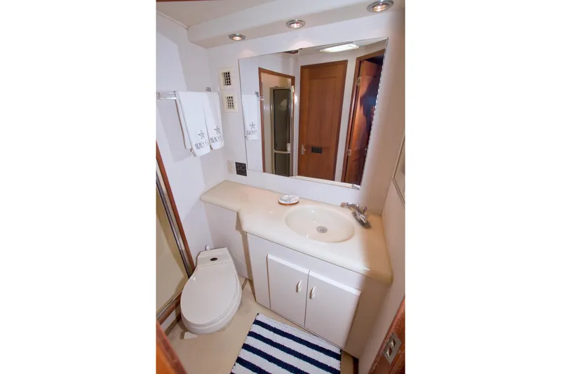 Slide: The Image of Bathroom interior of 1990 Viking 53 Convertible yacht, featuring sink, mirror, and toilet. - 64