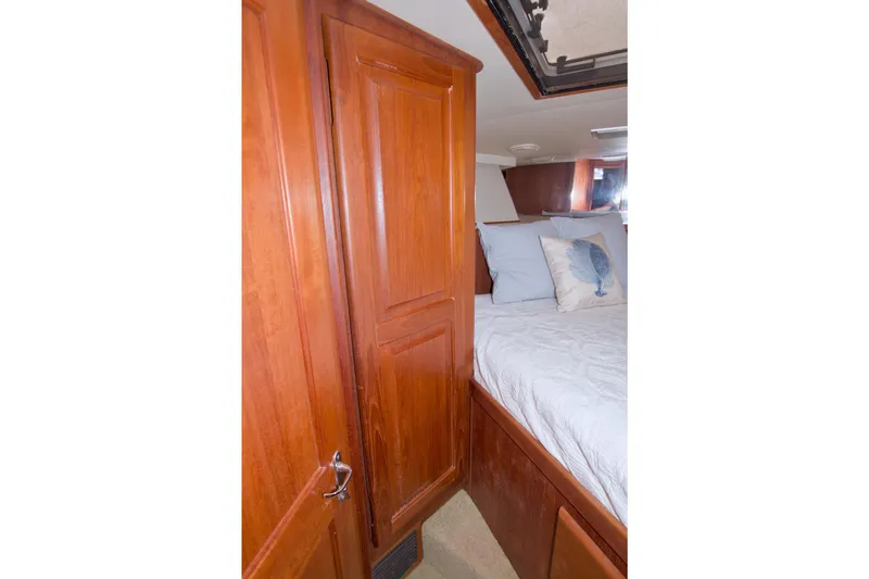 Slide: The Image of Cozy bedroom interior of 1990 Viking 53 Convertible yacht with wooden cabinetry. - 66