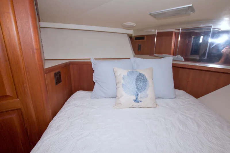 Slide: The Image of Cozy bedroom in 1990 Viking 53 Convertible yacht with decorative pillows and wood paneling. - 67