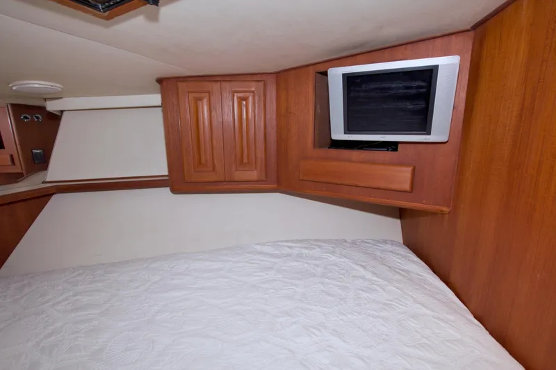 Slide: The Image of Cozy cabin interior of 1990 Viking 53 Convertible with TV and wooden cabinetry. - 69