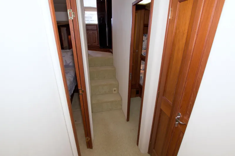 Slide: The Image of Interior hallway of 1990 Viking 53 Convertible yacht with wooden doors and carpeted stairs. - 70