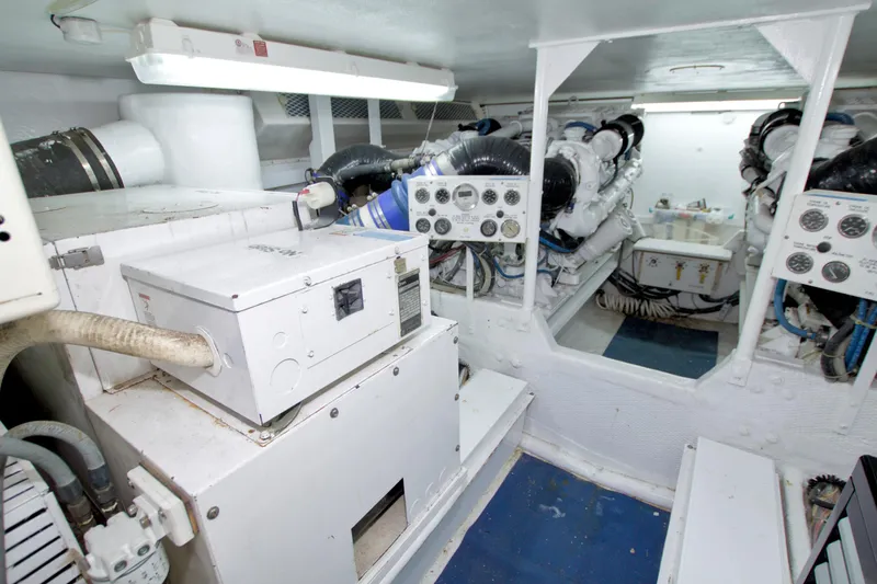 Slide: The Image of Engine room of 1990 Viking 53 Convertible yacht, featuring machinery and control panels. - 78