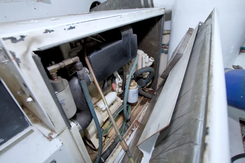 Slide: The Image of Engine compartment of a 1990 Viking 53 Convertible boat, showing mechanical components and hoses. - 80