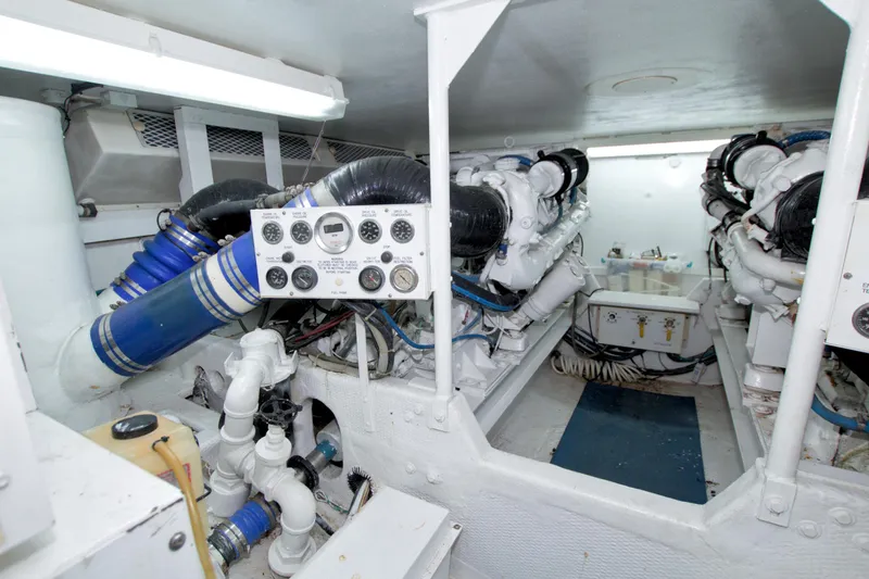 Slide: The Image of Engine room of a 1990 Viking 53 Convertible yacht, featuring complex machinery and control panels. - 83