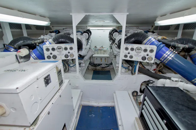 Slide: The Image of Engine room of a 1990 Viking 53 Convertible yacht, featuring control panels and machinery. - 84