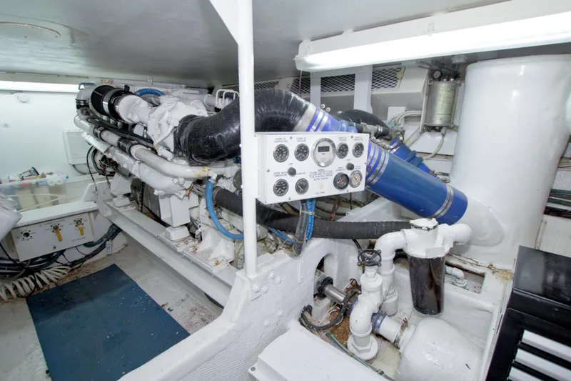 Slide: The Image of Engine room of a 1990 Viking 53 Convertible yacht, featuring complex machinery and control panel. - 85