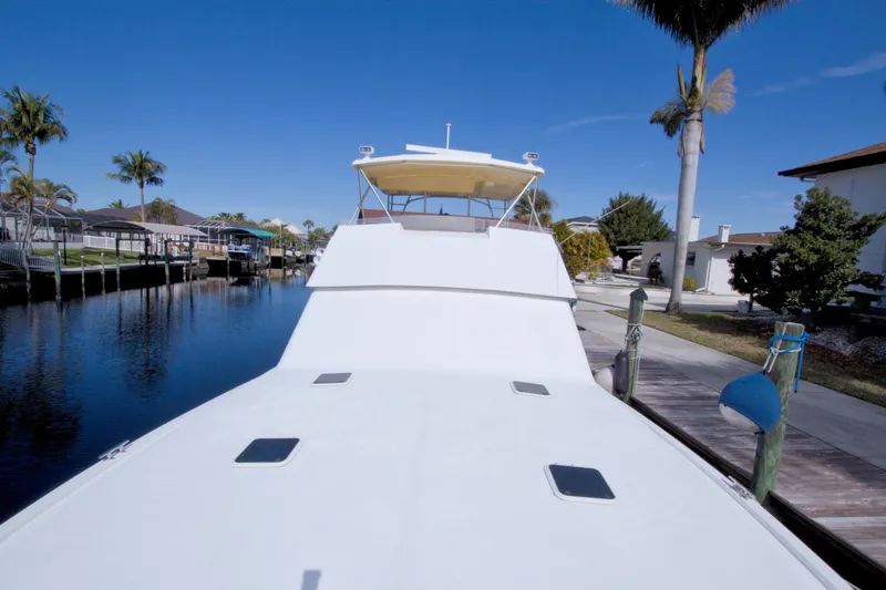 Slide: The Image of 1990 Viking 53 Convertible yacht docked by a canal under clear blue skies. - 9