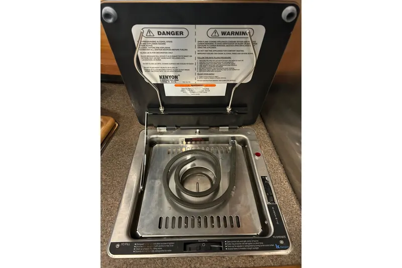 Slide: The Image of Electric stove in 2017 Ranger Tugs R-25 SC boat galley, featuring safety warnings. - 12