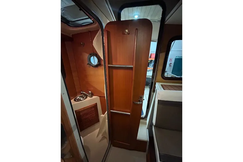 Slide: The Image of 2017 Ranger Tugs R-25 SC interior with wooden door and compact bathroom. - 21