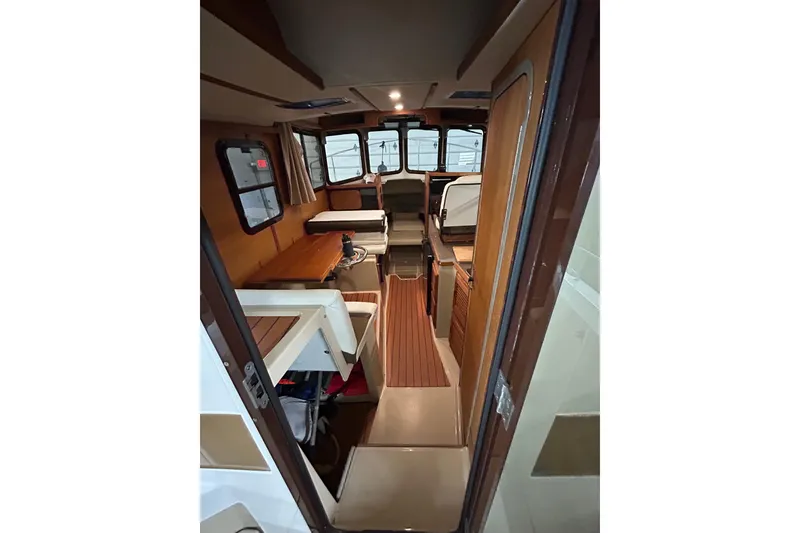 Slide: The Image of Interior of 2017 Ranger Tugs R-25 SC, featuring wood accents and seating area. - 25
