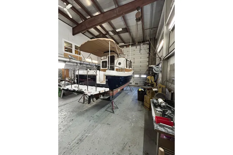 Slide: The Image of 2017 Ranger Tugs R-25 SC boat in a workshop, elevated on stands. - 3