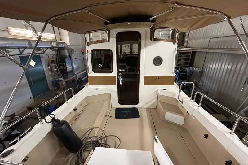 Slide: The Image of 2017 Ranger Tugs R-25 SC boat interior with canopy in a workshop setting. - 5