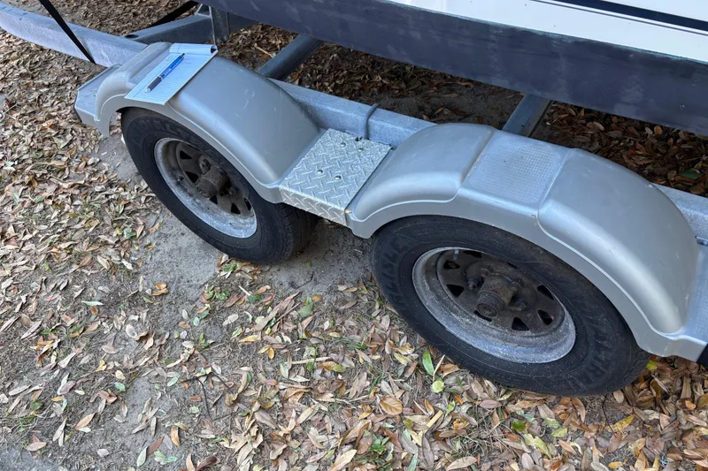 Slide: The Image of Trailer wheels for 2015 Boston Whaler 190 Outrage, surrounded by fallen leaves. - 14