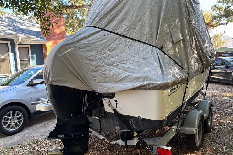 Slide: The Image of Covered 2015 Boston Whaler 190 Outrage boat on trailer, parked outdoors. - 15