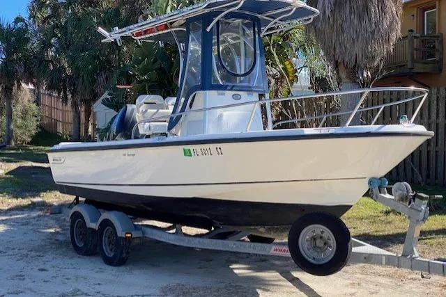Slide: The Image of 2015 Boston Whaler 190 Outrage boat on trailer, parked outdoors. - 4
