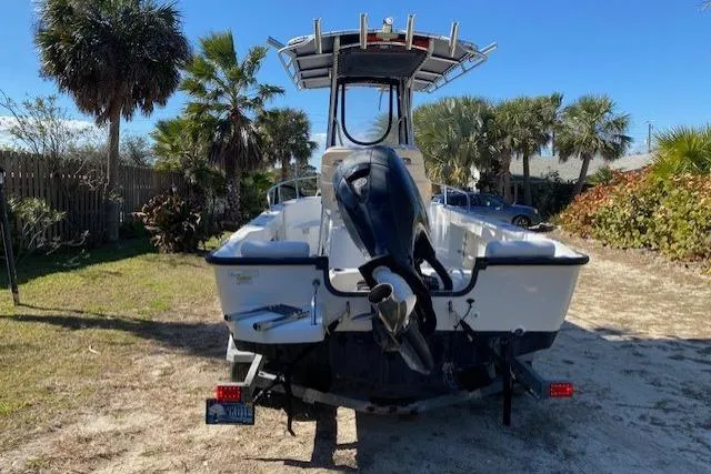 Slide: The Image of 2015 Boston Whaler 190 Outrage boat on trailer, surrounded by palm trees. - 8