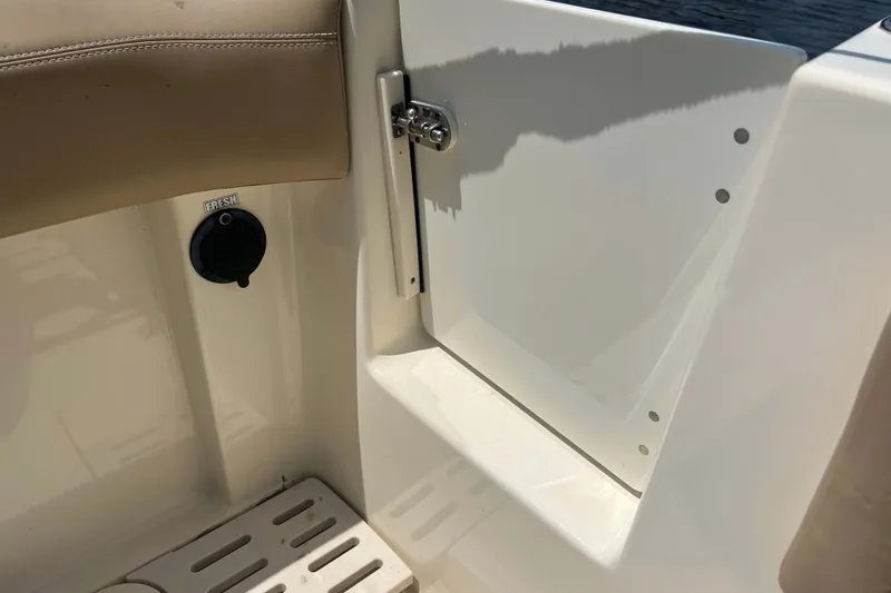Slide: The Image of 2021 Scout 305 LXF boat interior detail with fresh water access and storage compartment. - 13