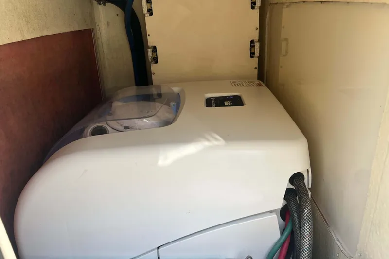 Slide: The Image of Compact washing machine in a small storage space on a 2021 Scout 305 LXF boat. - 16